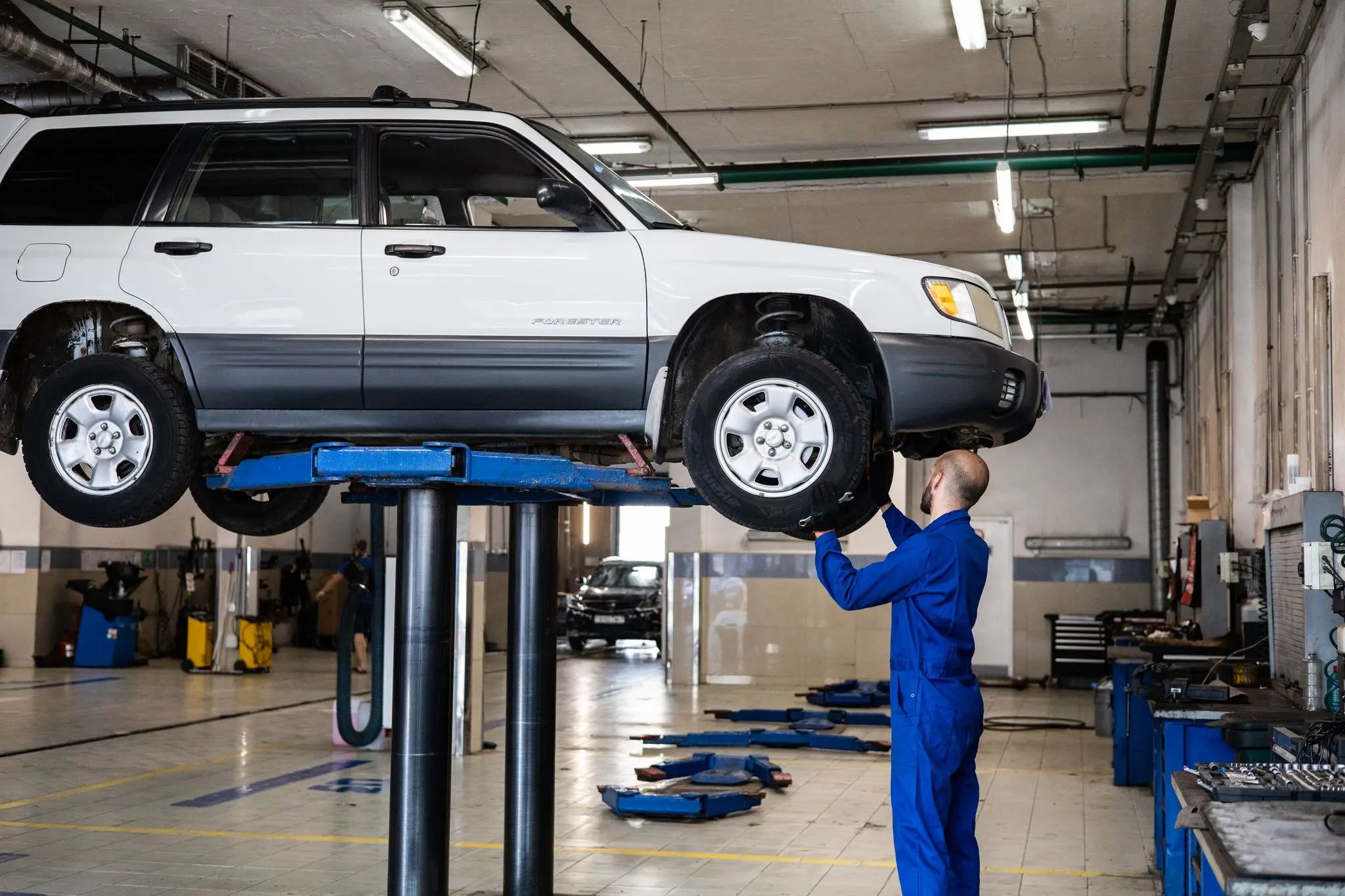 Mechanic inspecting a vehicle after collision repairs